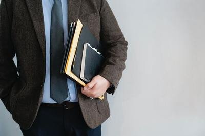 man in a suit carrying folders